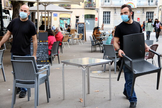Waiters in Barcelona clearing up a café terrace (by Jordi Bataller)